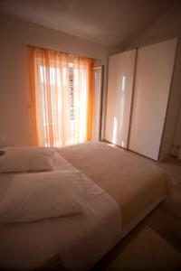 a bedroom with a large bed with a window at Apartments Svjetlana in Trogir