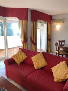 a red couch with yellow pillows in a living room at La Siesta de Mijas Golf 174 in Fuengirola +33 photos