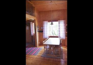 a dining room with a table and a cross on the window at Björkholm mökit in Pargas