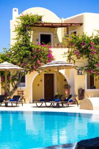 a resort with a swimming pool with chairs and umbrellas at Smaragdi in Perivolos