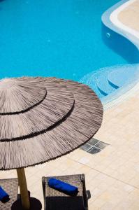 a umbrella and two chairs next to a swimming pool at Smaragdi in Perivolos