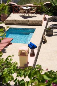 a swimming pool with a table and a chair and a table and a tablektop at Smaragdi in Perivolos