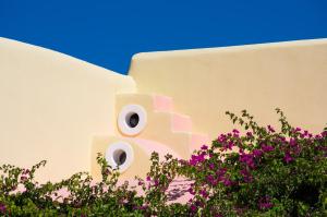 a building with a building with flowers in front of it at Smaragdi in Perivolos