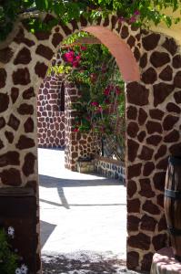 a stone archway with flowers in a courtyard at Smaragdi in Perivolos