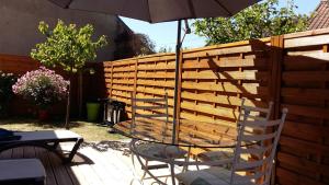 une table avec un parasol à côté d'une clôture en bois dans l'établissement Croix Montoire, à Tours