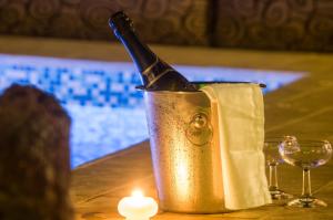 a champagne bottle in a bucket on a table with a candle at Smaragdi in Perivolos