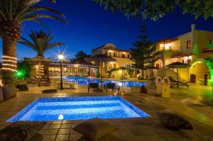 a swimming pool at night with a resort at Smaragdi Hotel in Perivolos