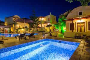 a swimming pool in front of a house at night at Smaragdi in Perivolos