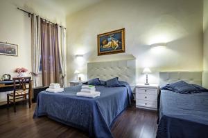una camera con due letti con lenzuola blu e un tavolo di B&B De Biffi a Firenze