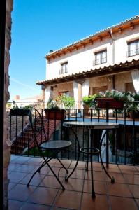 una mesa y sillas en un balcón con un edificio en La Casona de Lucía, en Sigüenza