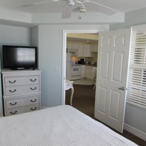 a bedroom with a bed and a flat screen tv at Edison Beach House in Fort Myers Beach