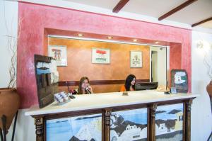 two women sitting at a counter in front of a mirror at Smaragdi in Perivolos