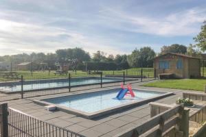 a pool with two slides in the middle of a yard at Groepsaccomodatie Tzummarum in Tzummarum
