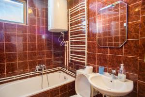 a bathroom with a toilet and a sink and a tub at Apartmani Mila in Žabljak +54 photos