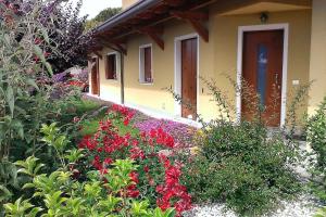 un giardino fiorito di fronte a una casa di Residence Stradella Verde a Staranzano