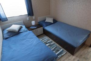 - 2 lits dans une chambre avec des draps bleus dans l'établissement Hnilčík Motorest pod Krížom, à Hnilčík