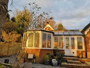 Paygate Cottage Brenchley في Brenchley: حديقة شتوية فوق منزل من الطوب