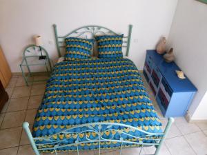 a bedroom with a bed with a blue and yellow blanket at Appartement au pied du gardon. in Remoulins