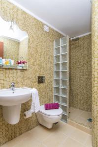 a bathroom with a sink and a toilet and a shower at Smaragdi in Perivolos