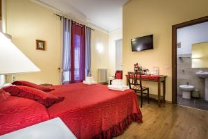 a hotel room with a red bed and a desk at B&B De Biffi in Florence