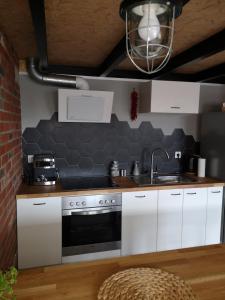 a kitchen with white cabinets and a sink at LoftStyle Apartament in Żyrardów +9 photos