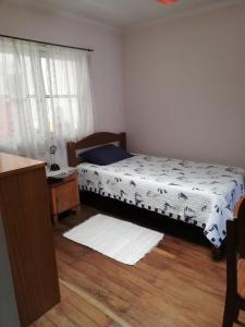 1 dormitorio con 1 cama y suelo de madera en Wayrashaus, en Cochabamba