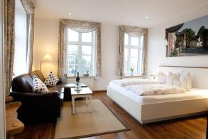 1 dormitorio con 1 cama blanca grande y 1 silla en Hotel Restaurant Friedrichs en Nebel