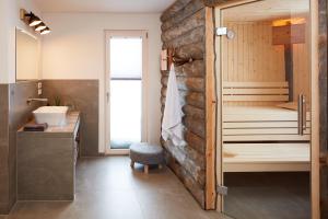 y baño con pared de piedra, ducha y lavamanos. en Beerenhaus, en Kurort Altenberg 8 fotos más