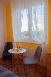 mesa y sillas en una habitación con ventana en BGMignonne, so cozy, so relaxing, so near center en Belgrado