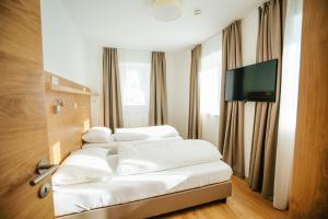 トレーポラッハにあるApartmenthaus Strasswirt De Luxeのホテルの部屋の白いベッド