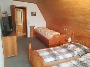 a room with two beds and a tv in a cabin at BIO-Peisingerhof in Sankt Stefan ob Leoben