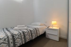 a bedroom with a bed and a nightstand with a lamp at Apartamentos Bello Tenerife in Santa Cruz de Tenerife