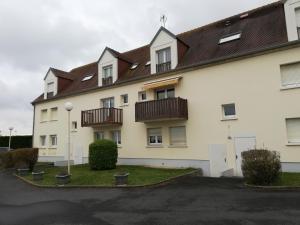a white building with balconies on the side of it at Charmant studio bord de mer in Ouistreham