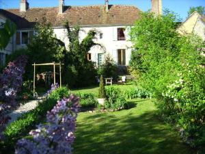 een tuin voor een huis met bloemen bij Maison Marthe B & B in Saint-Sauveur-en-Puisaye