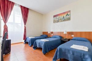 a hotel room with three beds and a tv at Roma Enrico Guesthouse in Rome