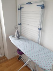 a ironing board in a room with a table at Sašo Rooms & Apartments in Ljubljana