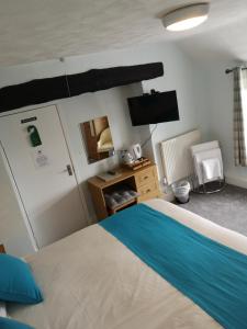 1 dormitorio con 1 cama y TV en Y Giler Arms en Pentrefoelas