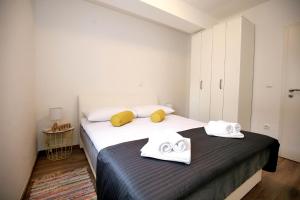 a bedroom with two beds with towels on them at NeRea Apartment Molat in Molat