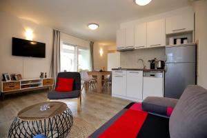 a kitchen and a living room with a couch and a table at NeRea Apartment Molat in Molat