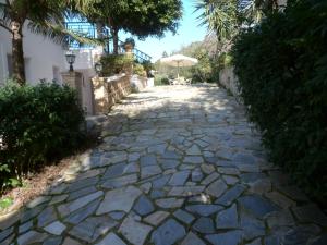 a stone walkway with an umbrella in a yard at Anna Studio and Apartments in Tsilivi