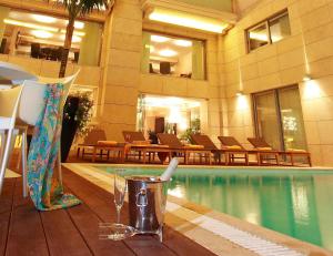 un hotel con piscina e un drink su un tavolo di Nafs Hotel a Nafpaktos