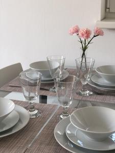 a table with plates and glasses and a vase with pink flowers at High 5 in Graz