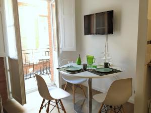 mesa de comedor con sillas y TV en la pared en Capitole Jeanne d Arc - Nice comfortable flat, central, balcony and charm en Toulouse