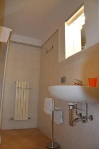 ein Badezimmer mit einem weißen Waschbecken und einer Dusche in der Unterkunft Studio Casta in Bellagio