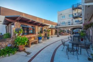 un patio con mesas y sillas frente a un edificio en Pismo Beach Hotel en Pismo Beach