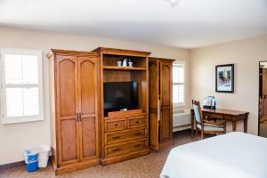 a bedroom with a tv and a wooden entertainment center at Casa Ojai Inn in Ojai