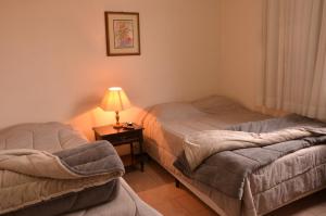 2 Betten in einem Zimmer mit einer Lampe auf einem Tisch in der Unterkunft Hotel Maristela in São Joaquim