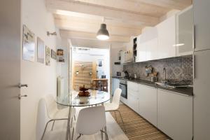 a kitchen with a glass table and white cabinets at Happy House in Viareggio