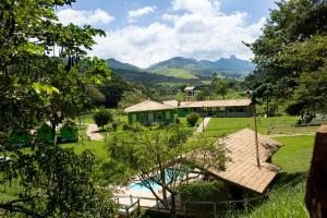 a view of a house with a pool and mountains at Pousada Casa Verde Baú in São Bento do Sapucaí