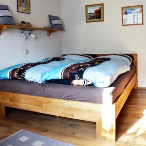 a bed with a wooden frame in a bedroom at Ferienwohnung Blockheide in Gmünd